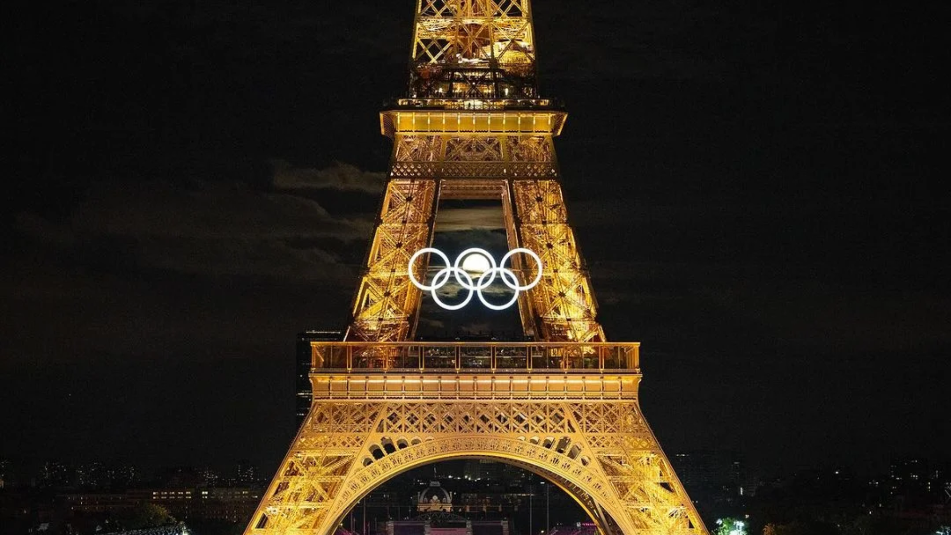 La luna se alinea perfectamente con anillos olímpicos en la Torre Eiffel